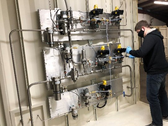 A technician at the high-pressure gas supply and conditioning panel.